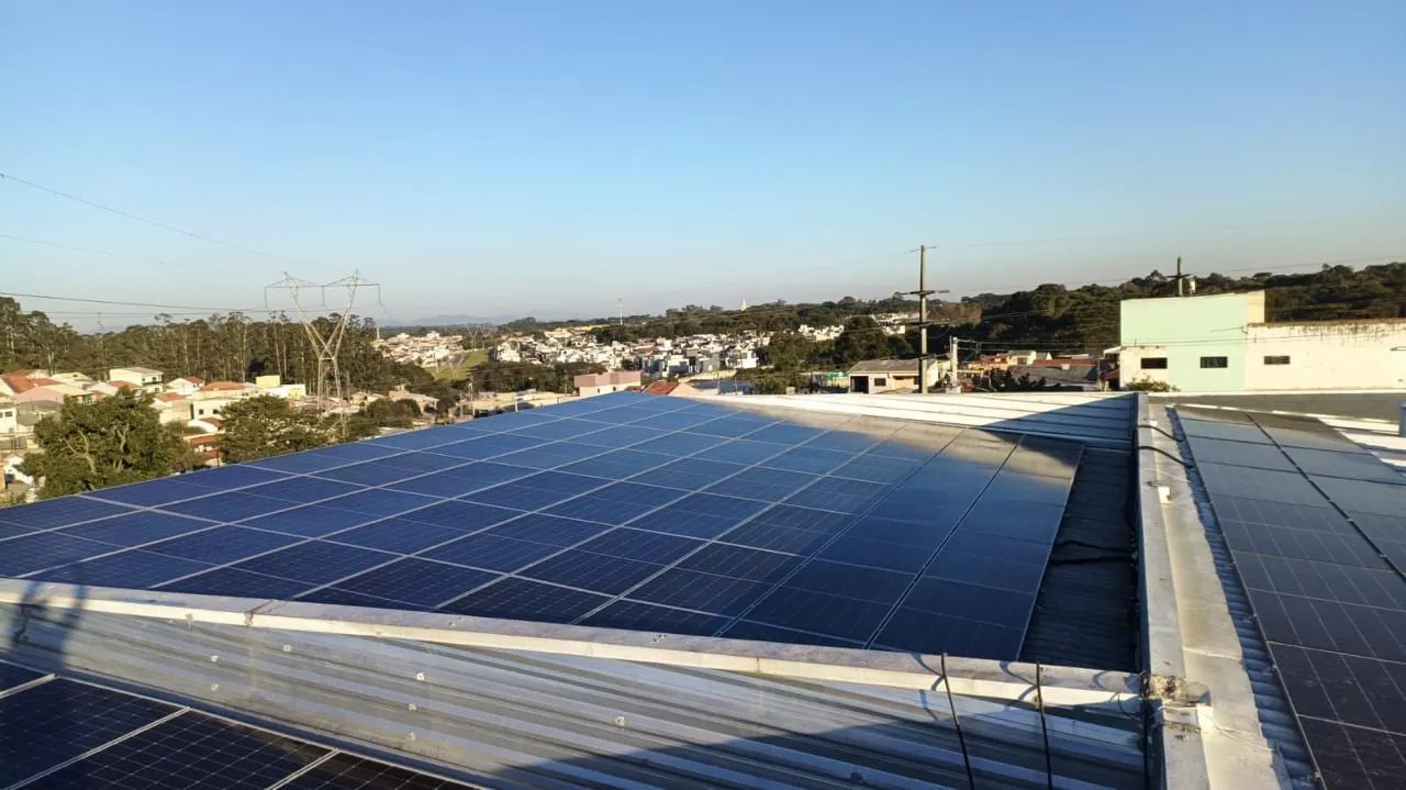 Usina solar sobre cobertura comercial com vista panorâmica da cidade