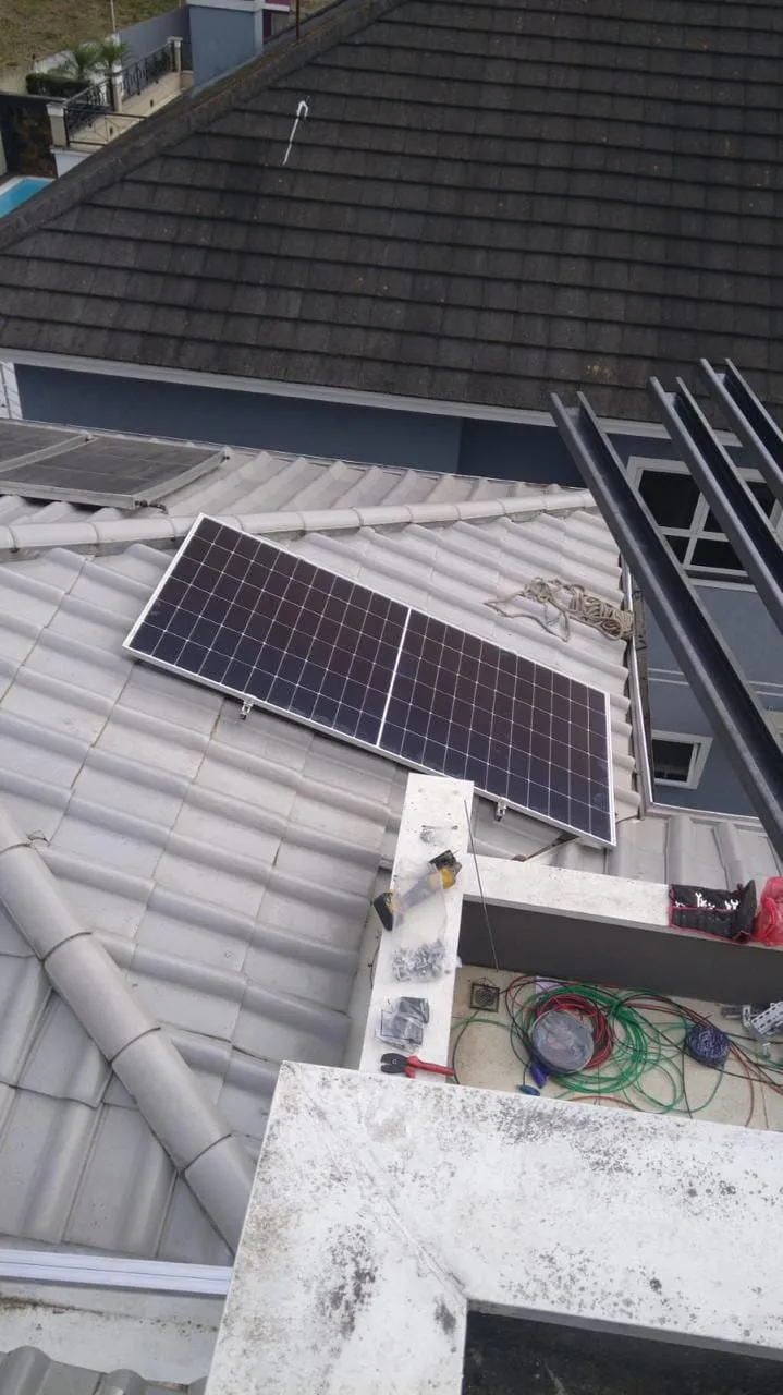 Módulo fotovoltaico fixado em telhado de telhas claras junto à estrutura de sustentação
