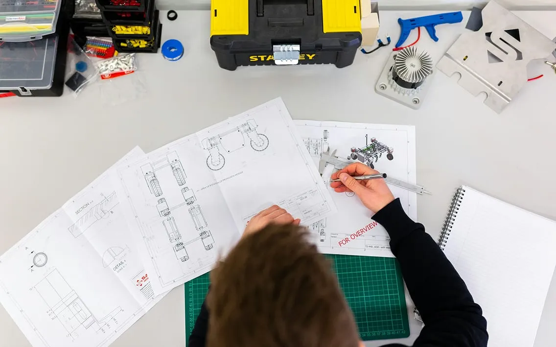 Engenheiro analisando plantas técnicas sobre a mesa
